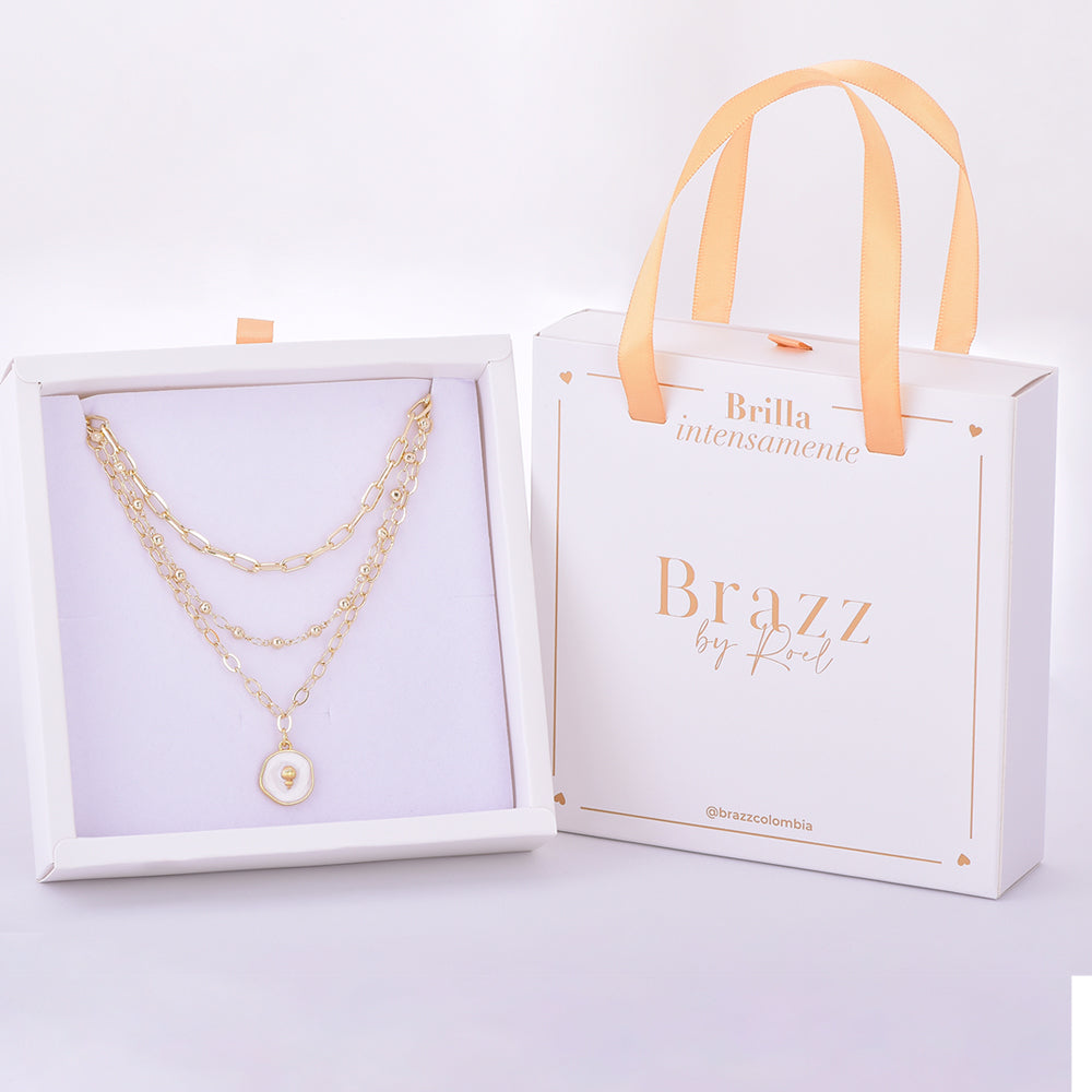 Set de collares en capas con medalla perlada y corazón dorado, presentado en caja de regalo Brazz by Roel.
