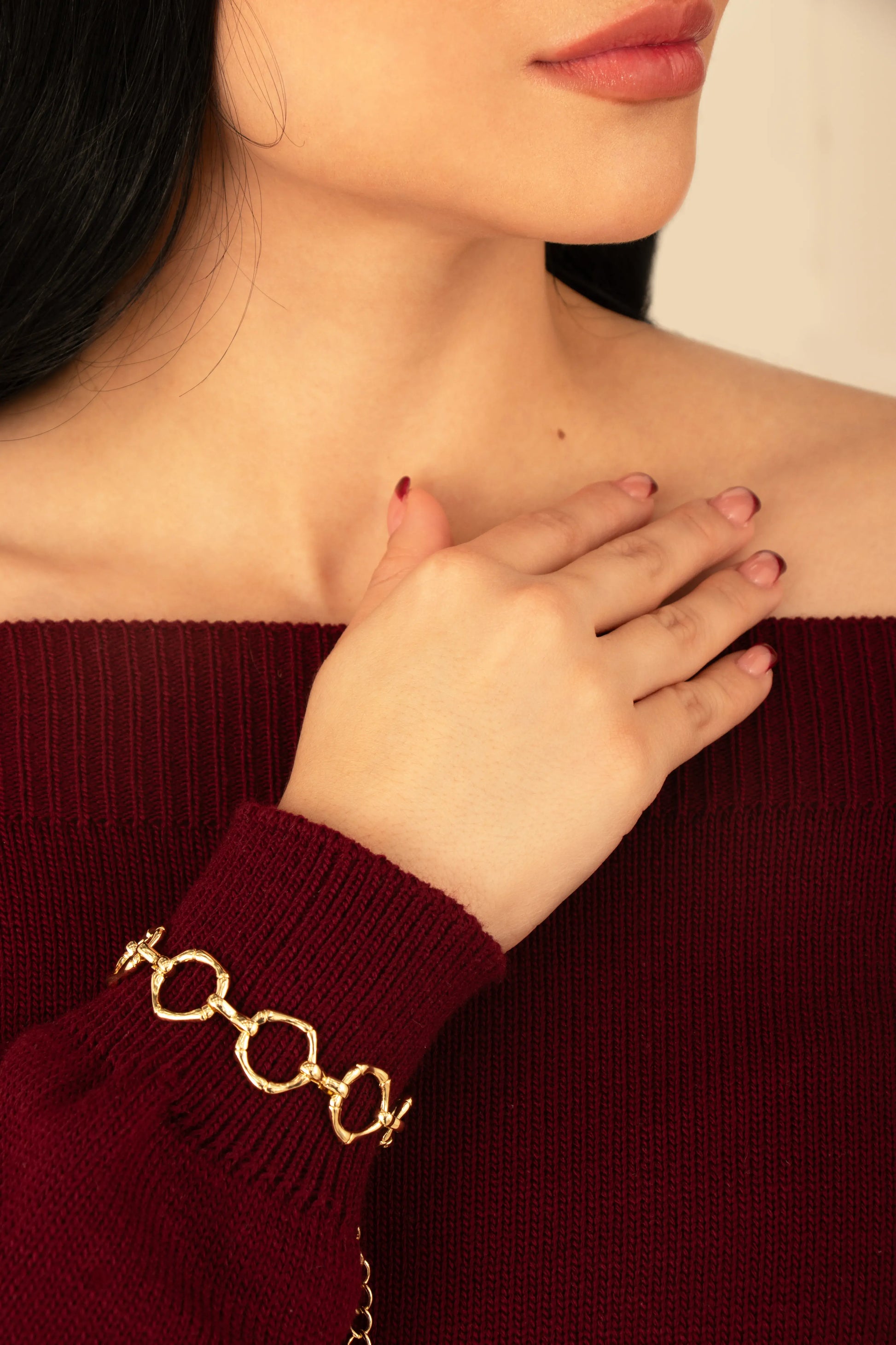 Brazalete dorado de eslabones martillados en baño de oro 24K, fotografía en muñeca de modelo.