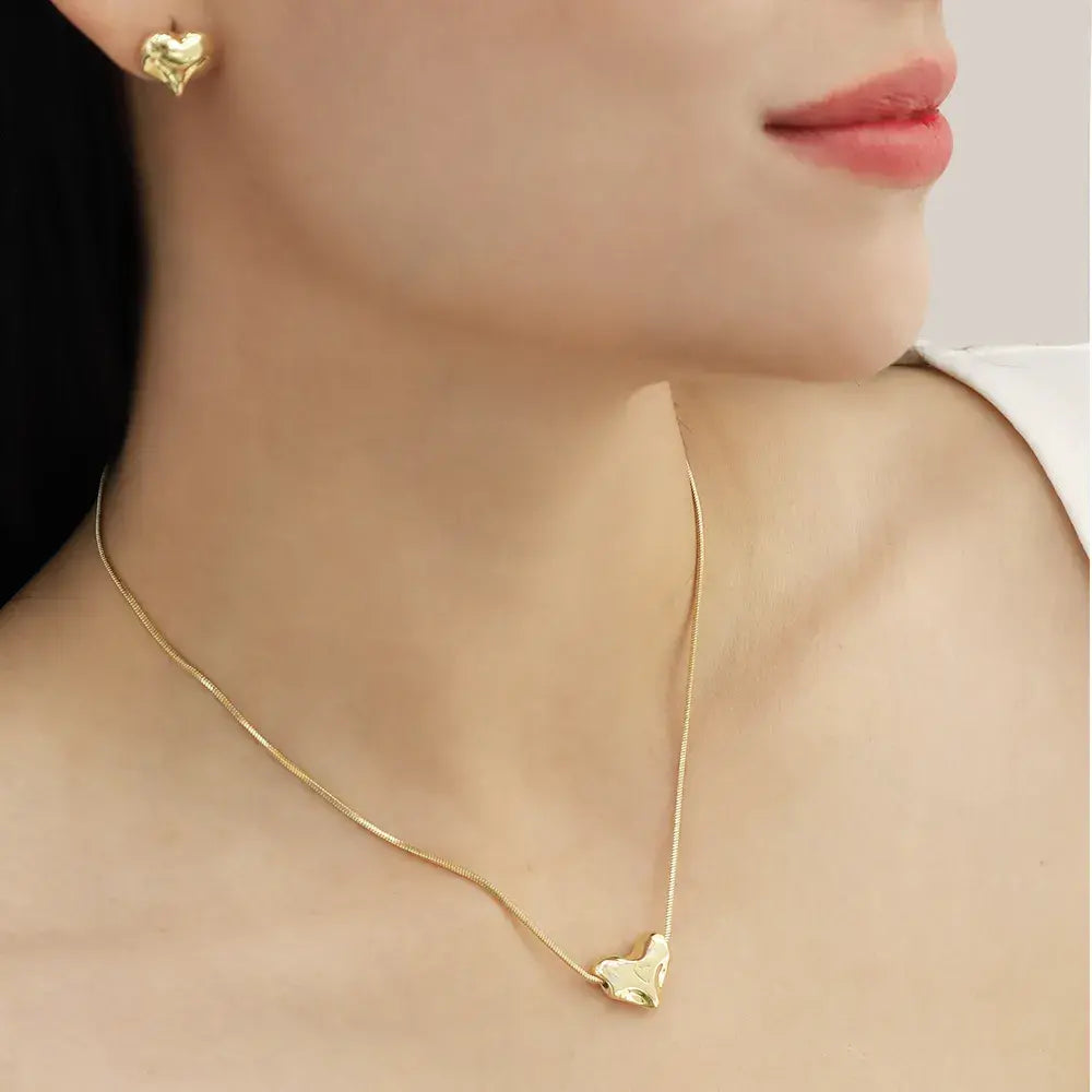 Juego de collar y aretes con corazones orgánicos en baño de oro 24K, fotografía en modelo.
