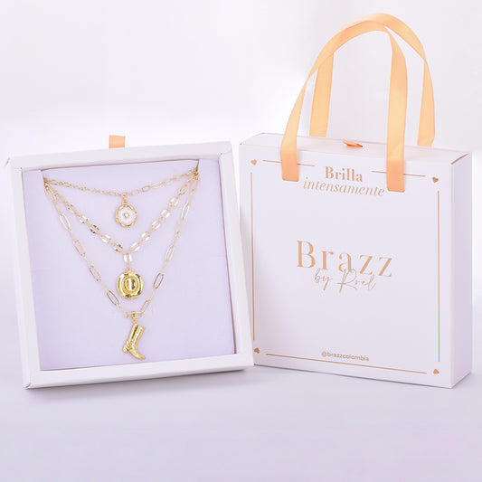 Set de collares en capas con charms dorados y empaque Brazz by Roel, en baño de oro 24K.